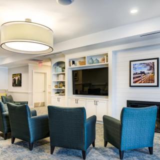 A modern living room featuring comfortable seating, a large television, and stylish decor.