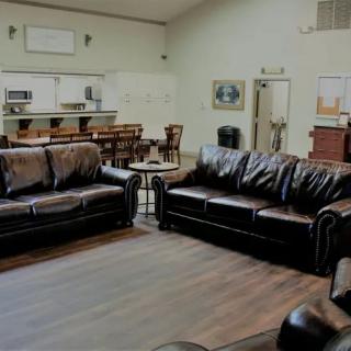 A cozy living room with leather sofas and a wooden floor.