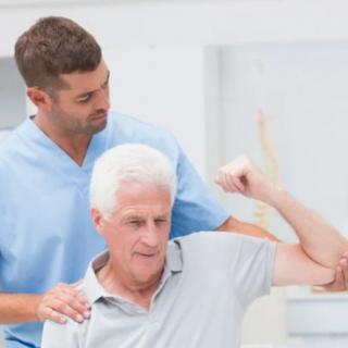 A healthcare professional assisting an elderly man with rehabilitation exercises.
