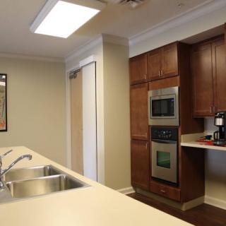 A modern kitchen featuring sleek appliances and warm wooden cabinetry.