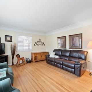 A cozy living room with a leather couch, hardwood flooring, and decorative elements.