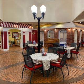 A cozy dining area featuring tables and chairs under decorative lighting.