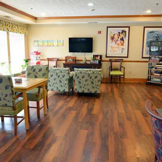 A cozy living room with comfortable seating, a television, and wooden floors.