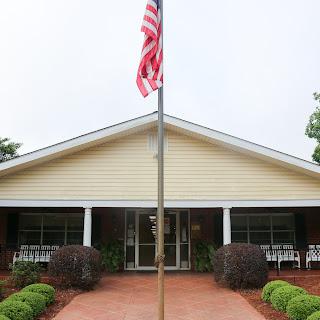 An inviting residential building with an American flag displayed in front.