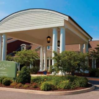 A grand entrance to a building with large columns and well-maintained landscaping.