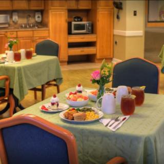 A cozy dining room setup with tables set for a meal, featuring various dishes and drinks.