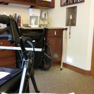 A cozy office space featuring a wheelchair and various furnishings.