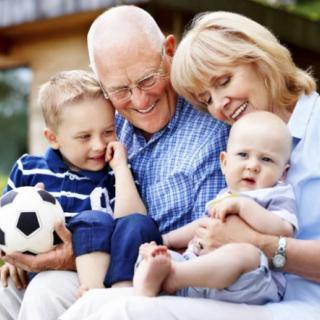 Grandparents enjoying time with their grandchildren outdoors.