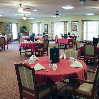 A well-arranged dining room with red tablecloths and neatly set tables.