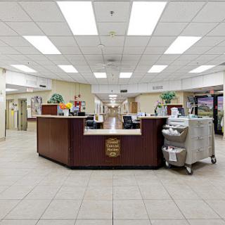 A spacious and well-lit reception area in a hospital, featuring a front desk and waiting area.