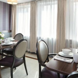 A well-lit dining room with elegantly set tables and comfortable chairs.