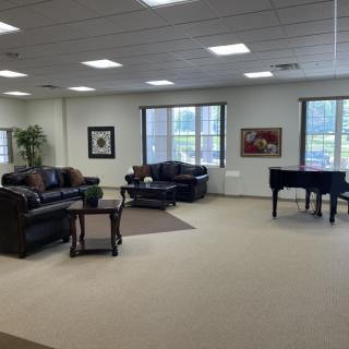 Spacious lounge area with sofas and a piano.