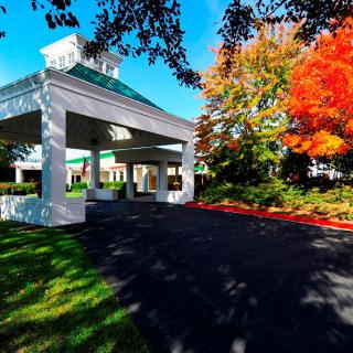 A building entrance surrounded by vibrant autumn foliage.