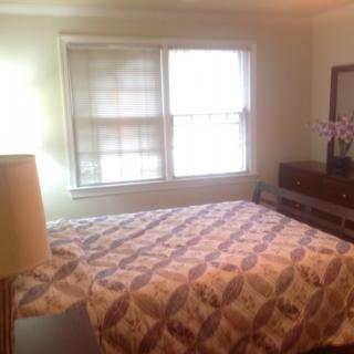 Cozy bedroom with a queen-sized bed and natural light from the window.