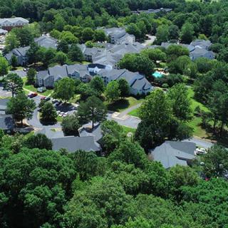 Aerial view of a lush residential neighborhood with houses surrounded by trees.