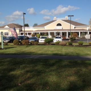 View of a hospitality building with an American flag and a well-manicured lawn.