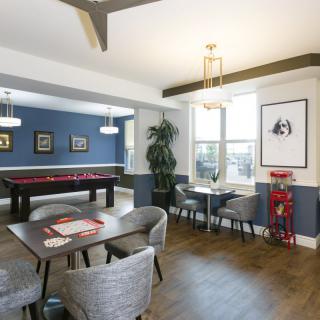 A modern game room with a pool table and comfortable seating area.