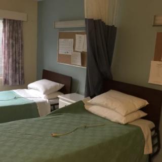 A hospital room with two beds separated by a curtain.