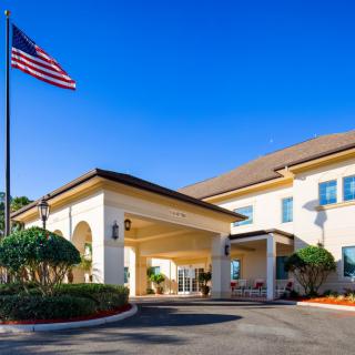 A hotel entrance with an American flag and clear blue sky in the background.