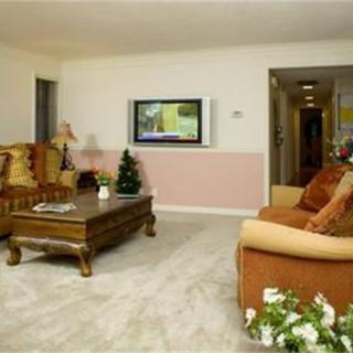 A cozy living room featuring comfortable sofas, a wooden coffee table, and a wall-mounted television.