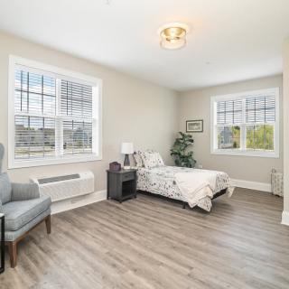 A minimalist bedroom with natural light and a single bed.