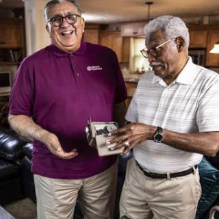 Two men share a joyful moment while interacting in a cozy indoor setting.