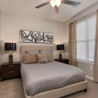 A modern bedroom featuring a neutral color scheme with a comfortable bed, stylish nightstands, and contemporary artwork.