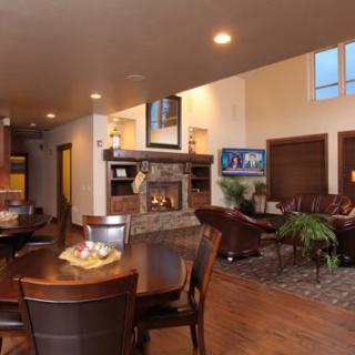 A cozy living room with a modern open floor plan featuring a fireplace and dining area.
