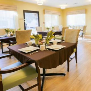 A modern and bright dining room with neatly set tables and comfortable chairs.