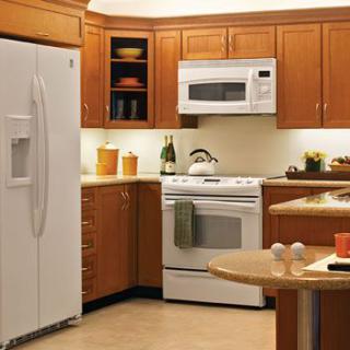 A modern kitchen featuring wooden cabinets and white appliances.