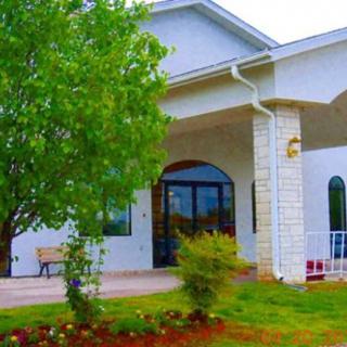 A picturesque view of a residential house with a lush garden and trees.
