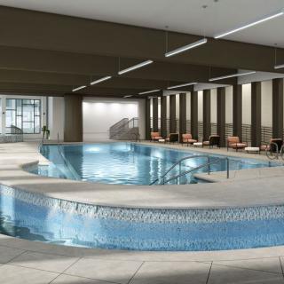 A modern indoor swimming pool with elegant design and seating area.