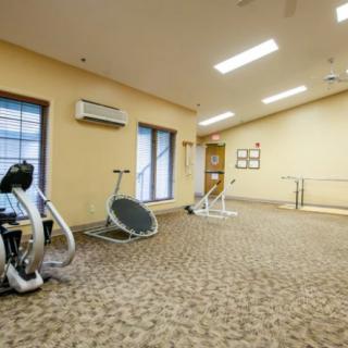 A spacious gym interior with modern exercise equipment and ample lighting.