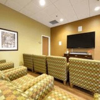 A cozy waiting room with patterned chairs and a television.