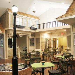 A cozy indoor cafe setting with tables, chairs, and a street-style lamppost.
