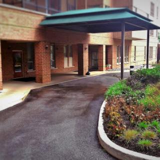 A welcoming entrance to a residential or commercial building, featuring a landscaped path.