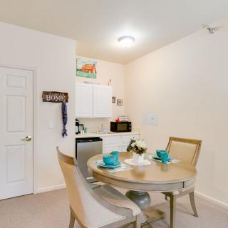 A cozy dining area with a round table and chairs, adjacent to a small kitchen.