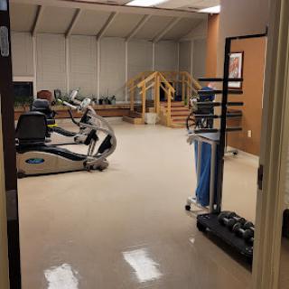 A view of a fitness room equipped with exercise machines and weights.