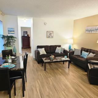 A modern living room featuring comfortable seating and a cozy dining area.