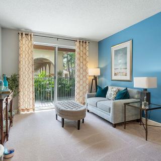 A stylish living room with a blue accent wall, modern furniture, and bright natural light.