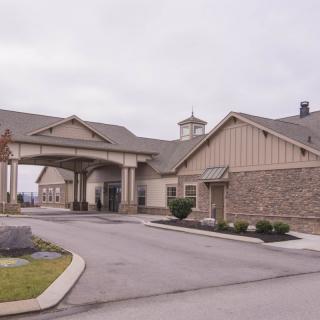 A suburban building with a covered entrance and parking area.