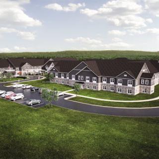 Aerial view of a modern residential complex surrounded by lush green hills.