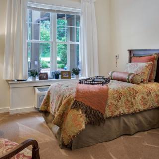 Cozy bedroom with elegant decor and a large window providing natural light.