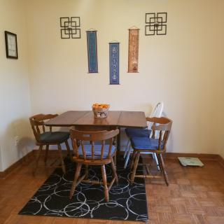 A cozy dining room with a wooden table, chairs, and decorative wall art.