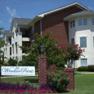 Entrance to a residential apartment complex with well-maintained landscaping.