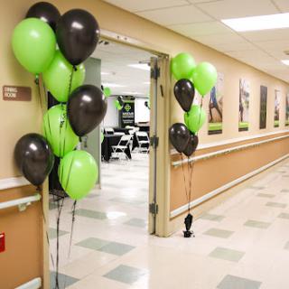 A festive entrance adorned with green and black balloons, welcoming guests into the celebration.