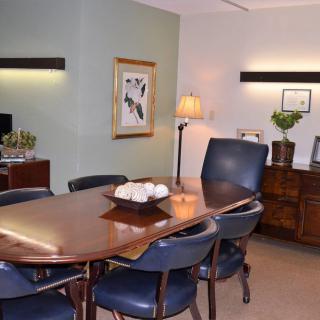A well-organized conference room with a polished wooden table and leather chairs.