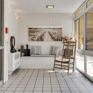 A cozy lobby area featuring a rocking chair, artwork on the wall, and ample natural light.