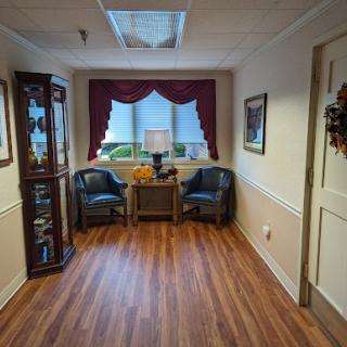 A cozy lobby area featuring two chairs, a decorative cabinet, and warm lighting.
