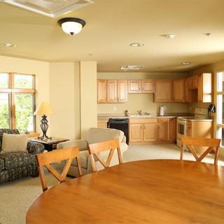 A modern open-plan living space featuring a kitchen, dining area, and sitting room.